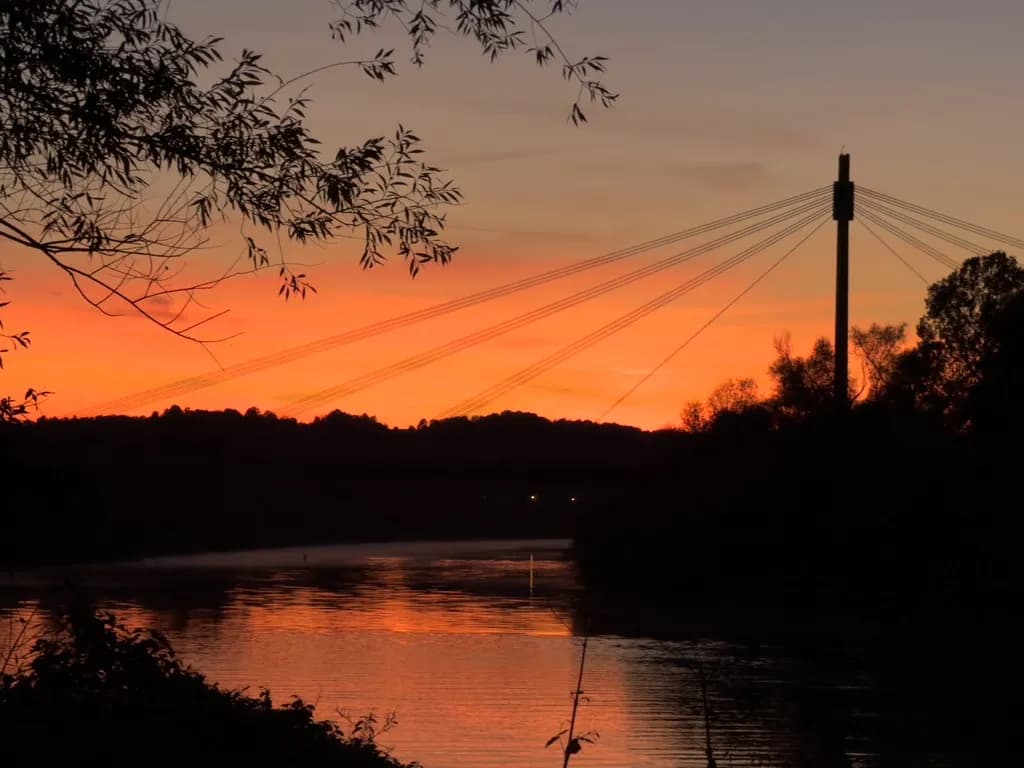 Photo showing sunset over the Vistula River in Krakow, with a balloon and Marshal Józef Piłsudski Bridge visible in the background